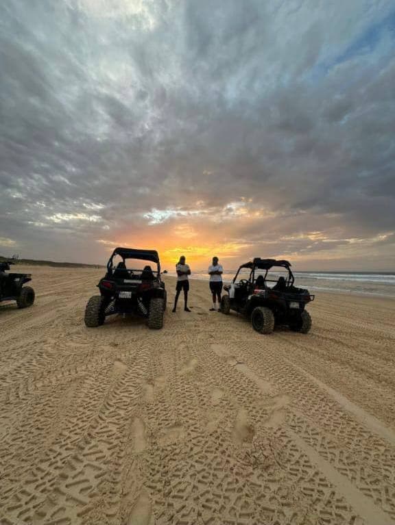 Buggys alignés sur la plage au coucher du soleil